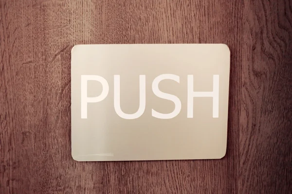 Signs showing the door with a push.