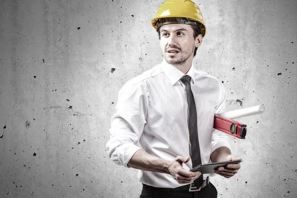 Engineer holding a touchpad and spirit level