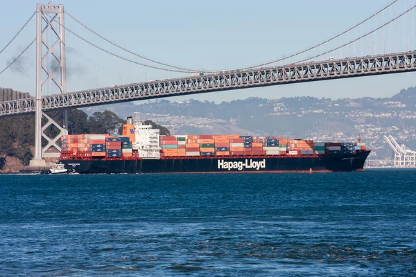 SAN FRANCISCO, US - SEPT 20, 2010: Hapag-Lloyd container ship moving under  Oakland Bay Bridge on its way to the Port of Oakland in San Francisco on Sept 20, 2010