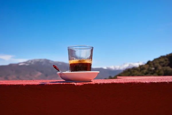 Cup of coffee standing on the wall. View of the Atlas mountains. Morocco.