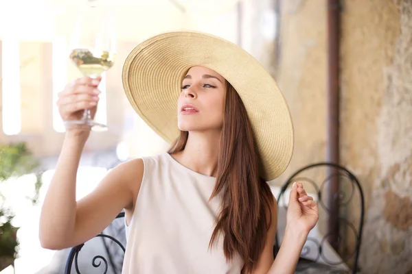 Young happy woman with glass of white wine