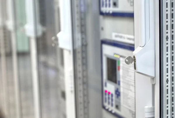 Front glass doors on electrical control cubicles and key in control room on modern electrical substation