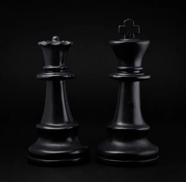 Chess. Black King and Queen on black background. The most powerful figures. Set of chess figures.