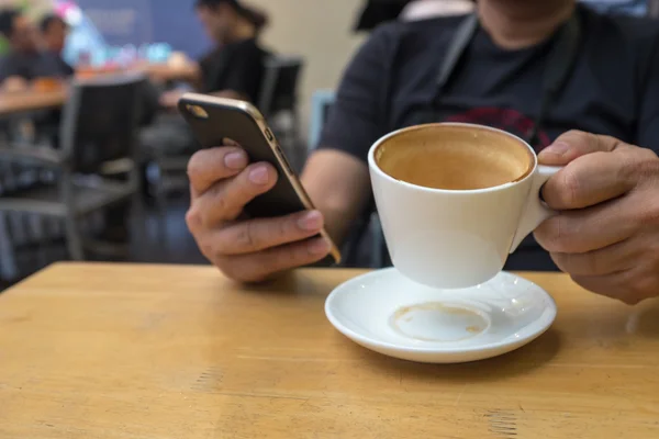 Man check updates on phone while having coffee