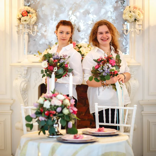 Young women holds a bouquet they made. Decor and floral composition on a table.