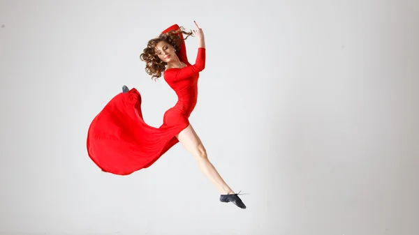 Dancing lady in a red dress. Contemporary modern dance on a white background isolated. Fitness, stretching model