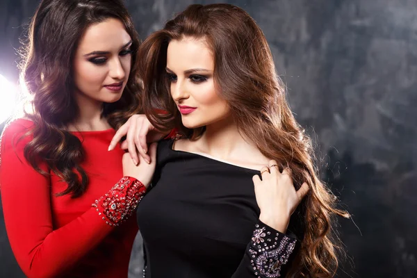 Two sexy elegant women in evening dresses with dramatic makeup and hairstyle, fashion beauty portrait