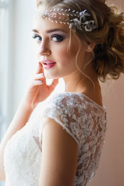 Beautiful blonde bride in gorgeous luxury dress in a loft space in a morning. Modern wedding photo