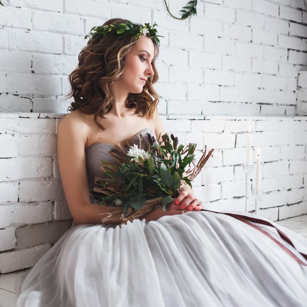 Beautiful tender bride holding creative wedding bouquet over green ecological style decor