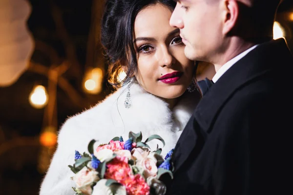 Wedding couple bride and groom together in a winter street decoration