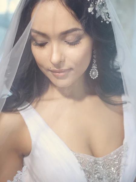 Beautiful bride under bridal veil in a morning. Wedding day