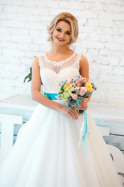 Gorgeous elegant bride in luxury wedding dress in a white loft space