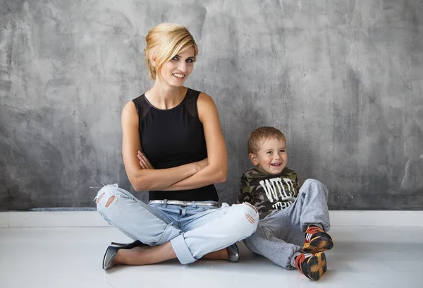 Beautiful blonde stylish young woman and her son in studio photoshoot