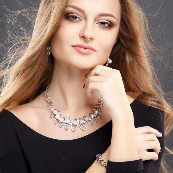 Close-up portrait of beautiful young woman with luxury jewelry and perfect make up. Fashion beauty portrait