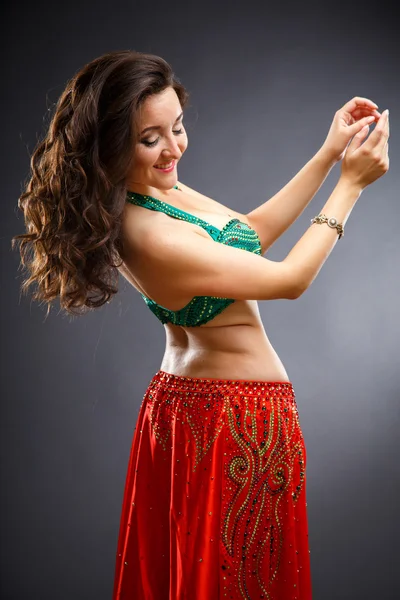 Beautiful belly dancer young woman in gorgeous red and green costume dress