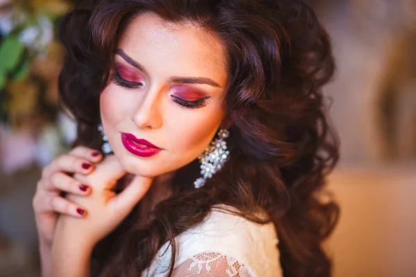 Close-up portrait of gorgeous beautiful bride in white dress with amazing hair style and make up, holding bouquet