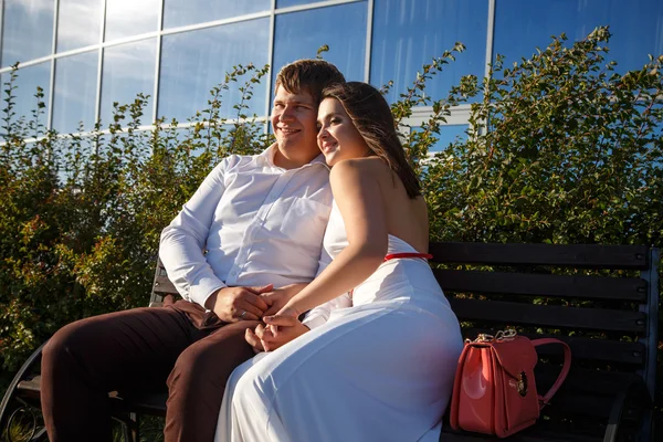 Beautiful couple man and woman rests and walks together near luxury building in a summer day