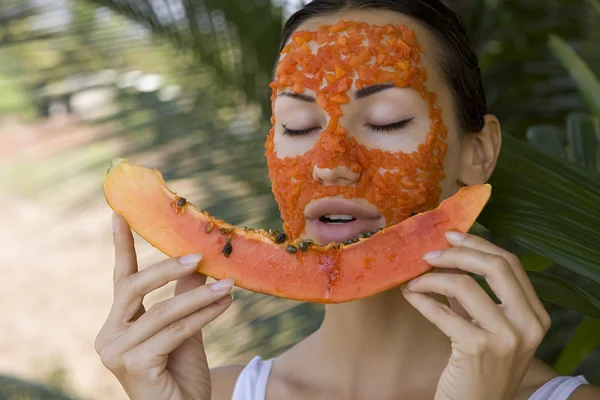 Beautiful woman having fresh papaya facial mask apply. fresh pap