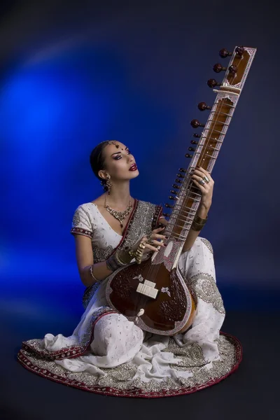 Beautiful Indian Woman in Sari with Oriental Jewelry Playing the