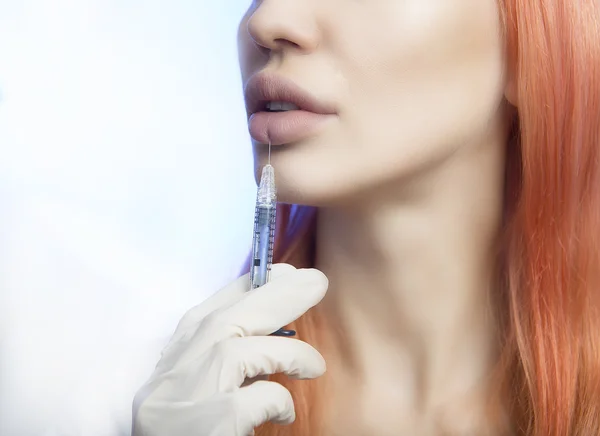 Woman Geting an Injection in her Lips in Beauty Salon