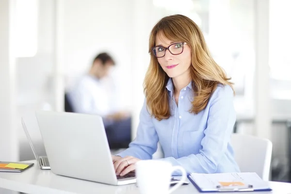 L woman sitting in  office and working