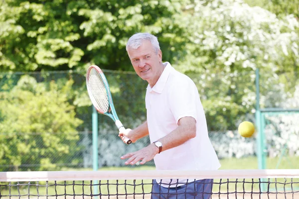 Senior man playing tennis.