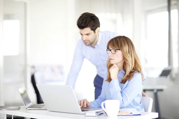 Businesswoman and  man using laptop
