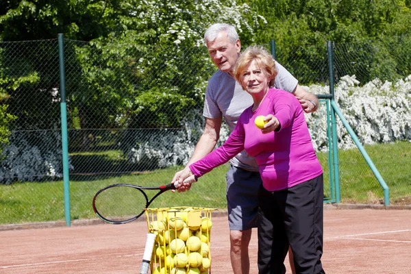Trainer playing tennis with woman
