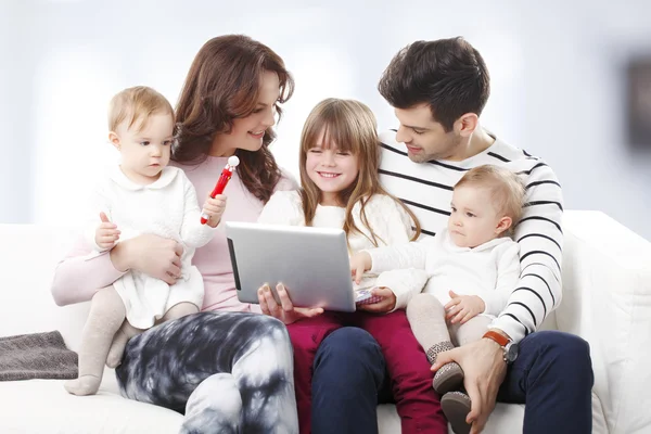 Family at sofa using digital tablet