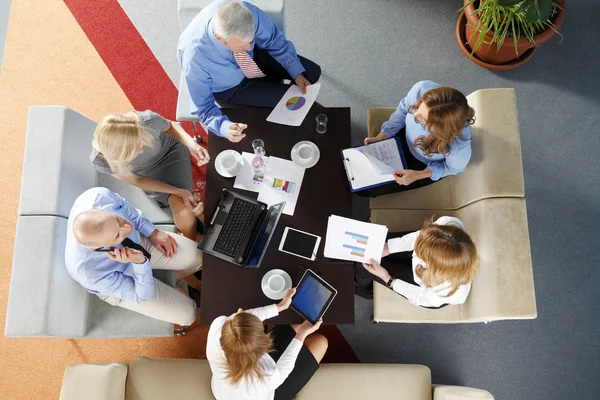 Business people sitting around desk