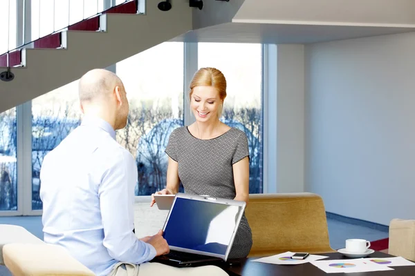 Businesswoman and businessman sitting at office