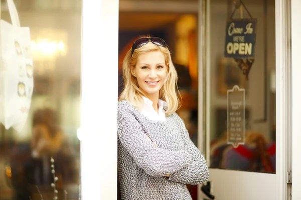 Confident female owner at shop facade