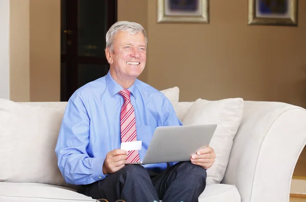Senior man shopping online with laptop