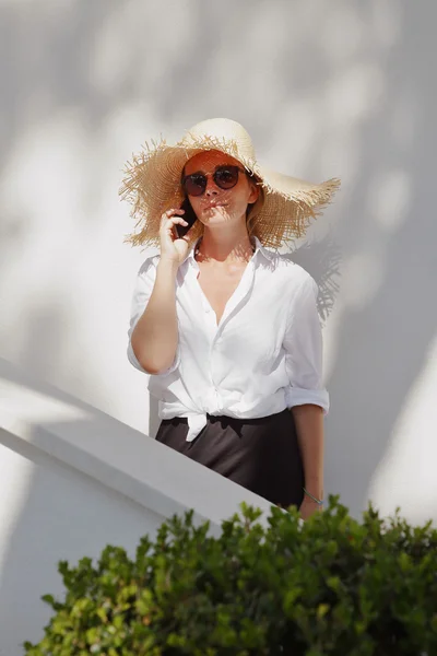 Woman wearing straw hat and sunglasses