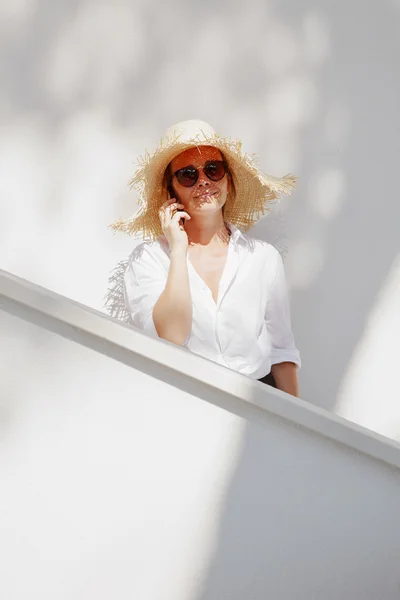 Woman wearing straw hat and sunglasses