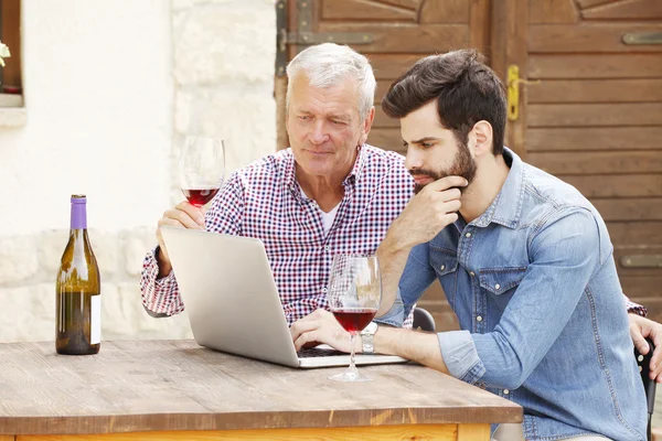 Winemakers sitting in front of computer