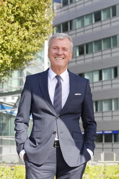 Director standing in front of office building