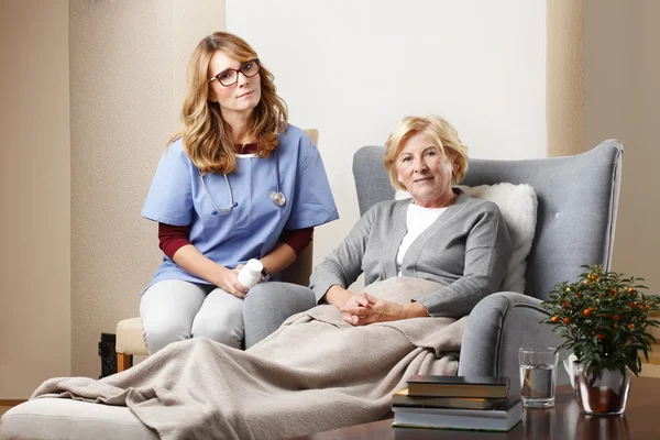 Caregiver sitting with senior patient