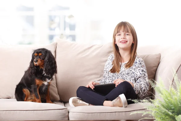 Girl sitting with her pet on sofa