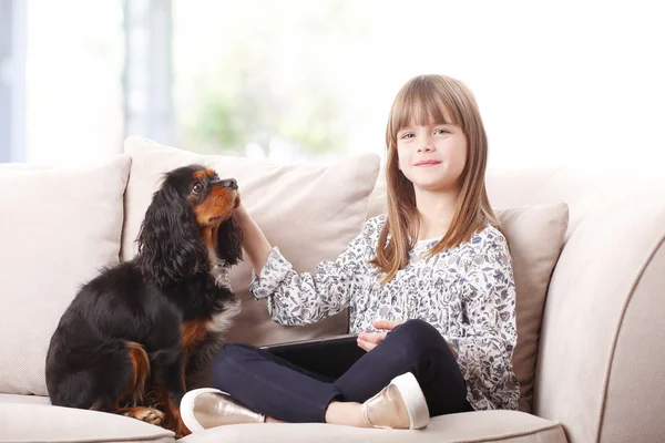 Girl sitting with her pet on sofa