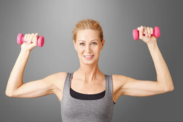 Blond woman working out with weights