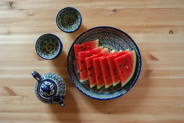 Fresh watermelon in restaurant in Samarkand and traditional uzbek ceramic teapot with piola