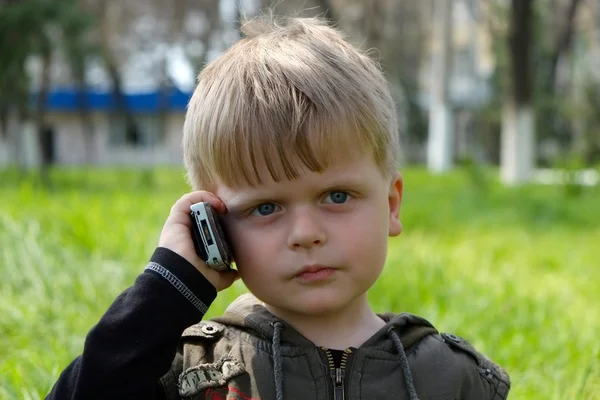 Boy talking by old mobile phone in the park