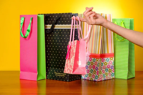 Female hand holding pink shopping bag