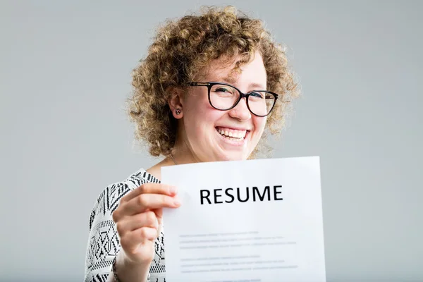 Curly woman showing her resume on a gray background