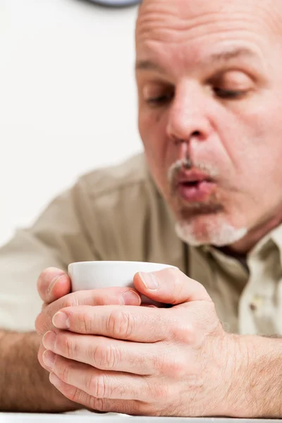 Close up of man blowing into cup