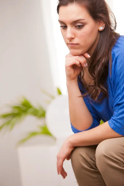 Thoughtful woman in her living room