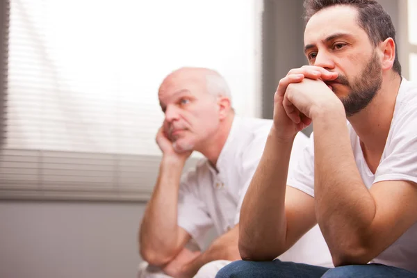 Men concerned about something in a living room