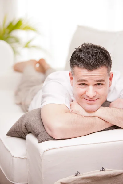 Man smiling to camera relaxing in his living room