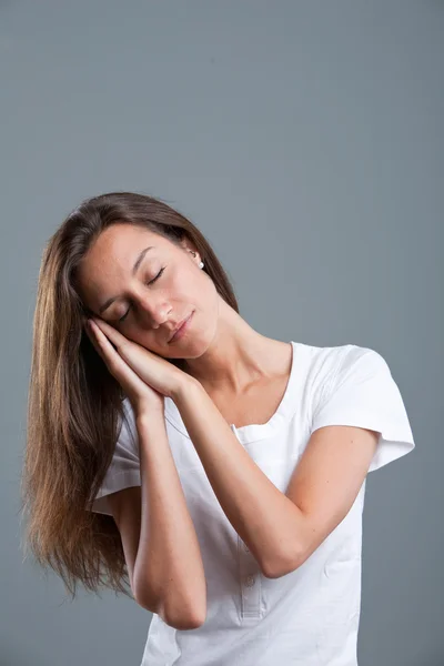 Young woman pretending sleep gesture